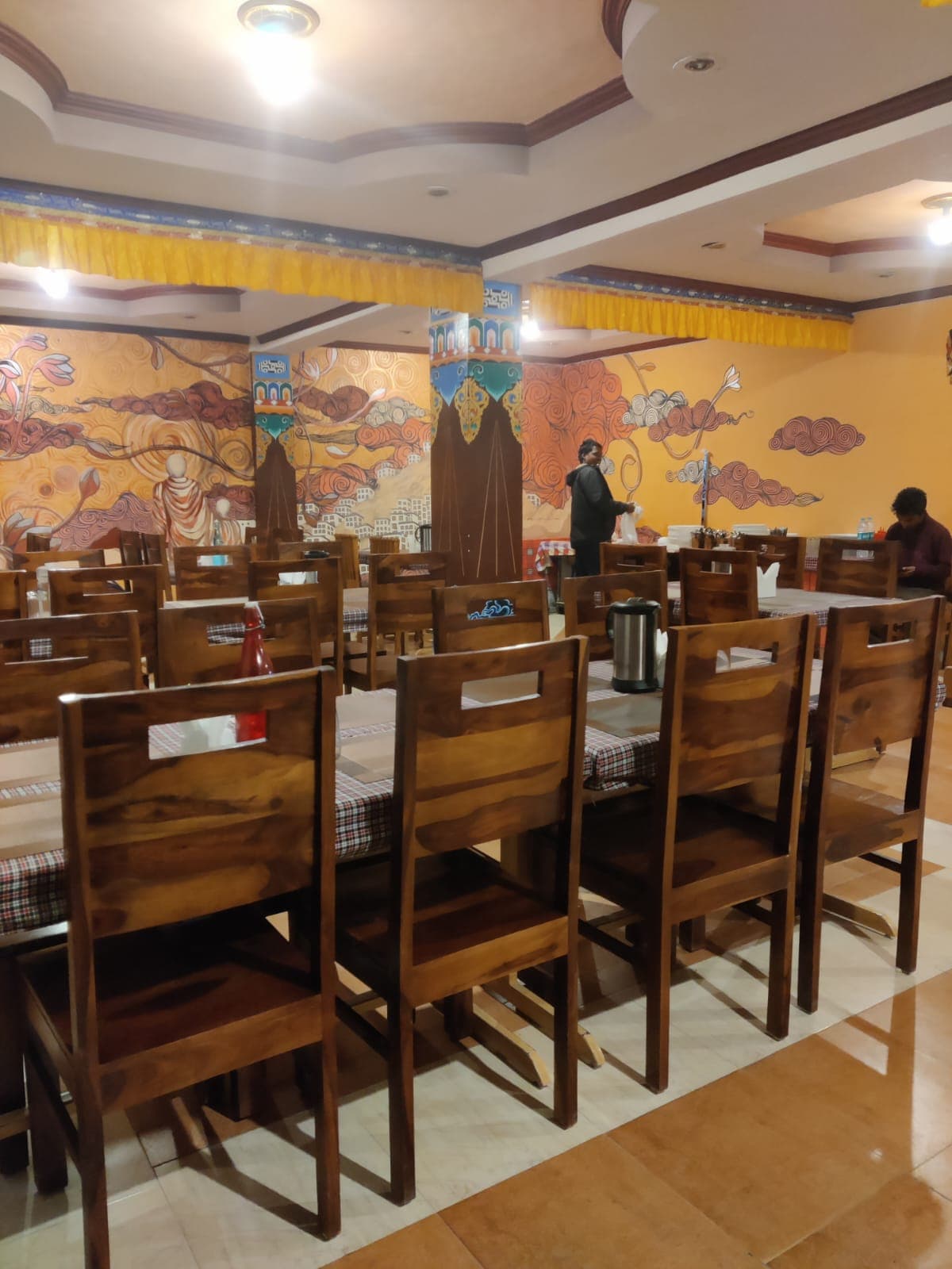 Delek Cafe seating with wooden furniture and wall murals